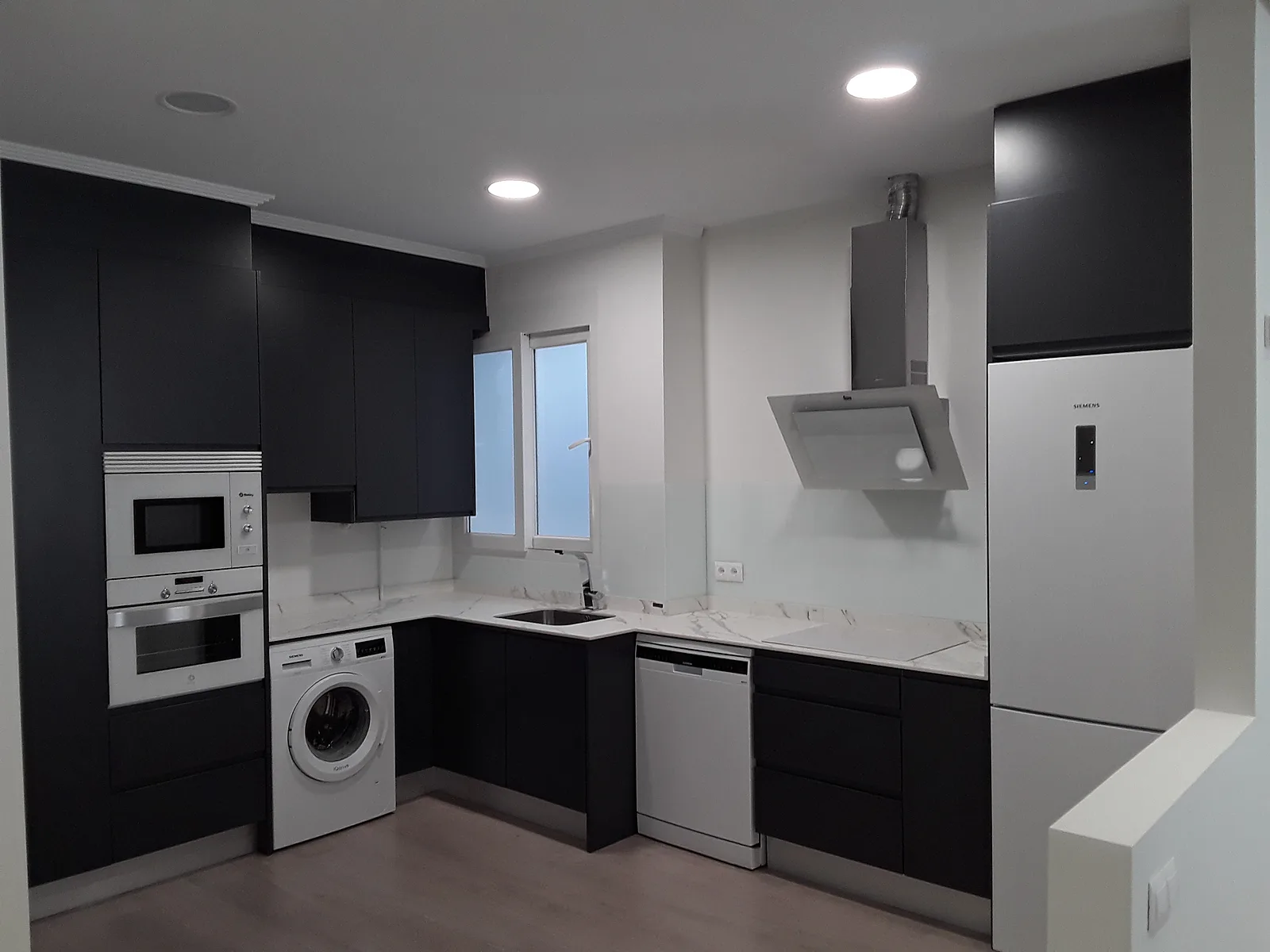 Cocina a medida en antracita con encimera blanca veteada