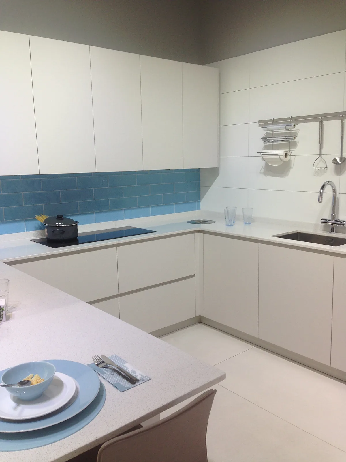 Cocina blanca a medida con frente de azulejo azul