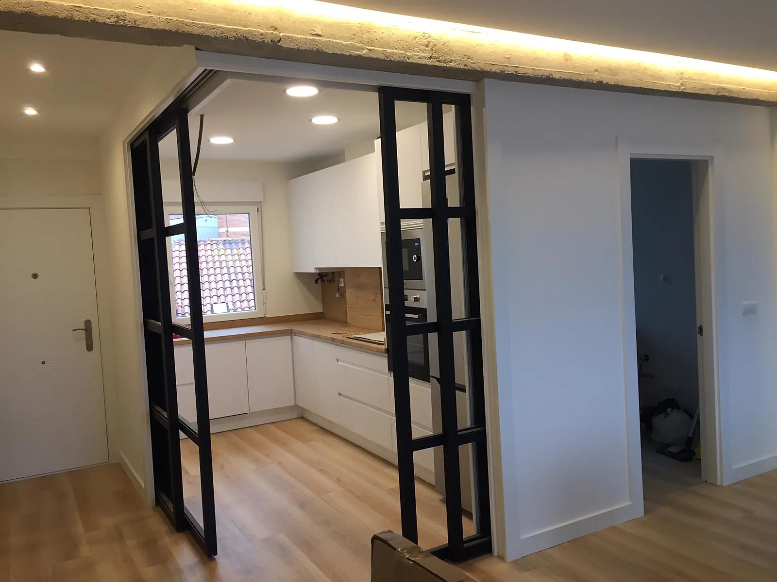 Cocina a medida con cerramiento de cristal y perfil negro estilo industrial
