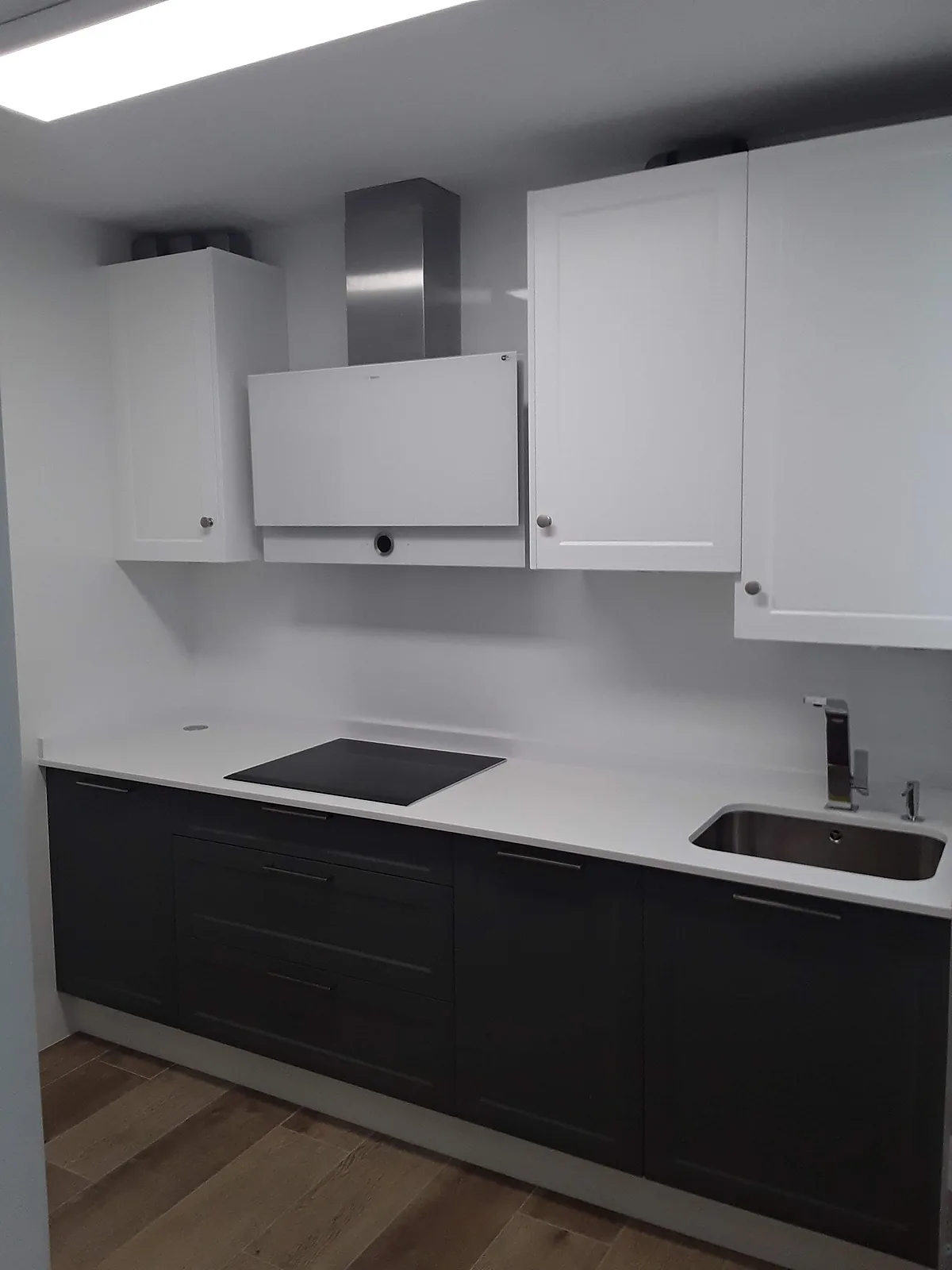 Cocina a medida bicolor con muebles altos blancos y bajos en gris oscuro