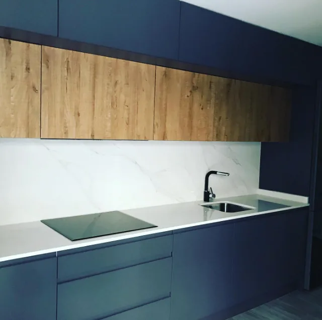 Cocina a medida de diseño con acabado azul oscuro y madera natural en Cantabria