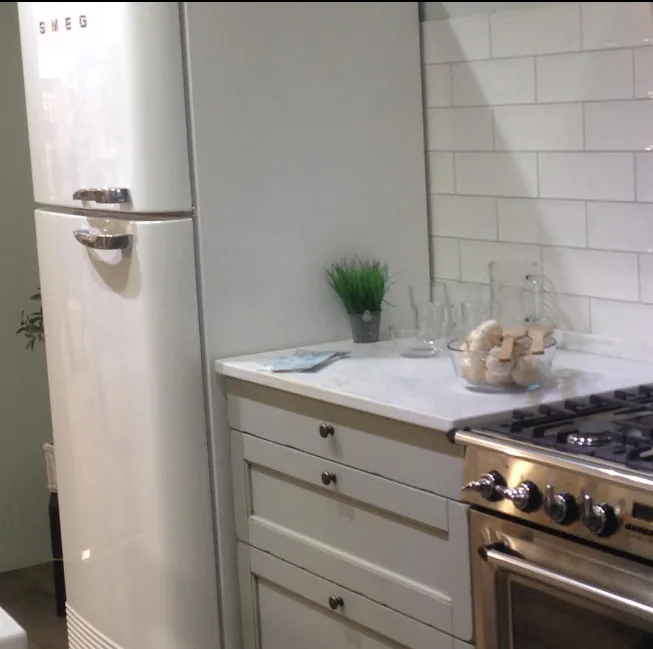 Cocina a medida de estilo clásico con muebles blancos y electrodomésticos vintage