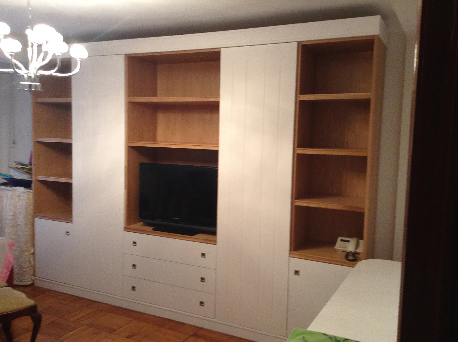 Mueble de salón a medida con hueco para televisión y estanterías de madera